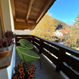 balcone con 2 sedie e fiori di Apartmenthaus Beaverwier a Biberwier