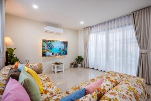 a living room with a couch and a large window at BUDDe' Cozy House วิลล่าอบอุ่น&ใกล้เมืองใกล้ทะเล in Hua Hin +61 photos