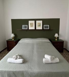 a bedroom with a large bed with towels on it at Green House Caldiero in Caldiero