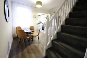 コルチェスターにあるStylish & Cosy Stay 2-Bed House Train Station Hospital Garden Fast WiFiのダイニングルーム、キッチン(テーブル付)、階段