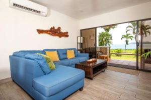a living room with a blue couch and a table at Newly Remodeled Ground-Floor Unit in Flamingo in Front of Beach in Playa Flamingo