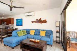 a living room with a blue couch and a table at Newly Remodeled Ground-Floor Unit in Flamingo in Front of Beach in Playa Flamingo +23 photos