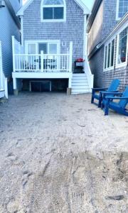 a patio with a blue bench and a house at Perkins Cove Oceanfront Cottage in Ogunquit