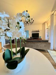 een vaas met witte bloemen op een tafel in een woonkamer bij Casa Caboz in Ponta do Sol +22 foto's