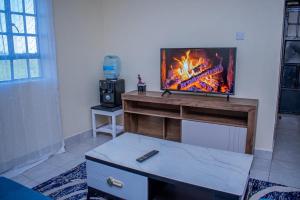 a living room with a flat screen tv on a stand at Olive Homes Thika Town in Thika