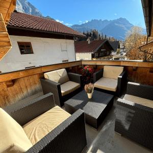 balcone con sedie e tavoli in vimini e montagne di Apartmenthaus Beaverwier a Biberwier