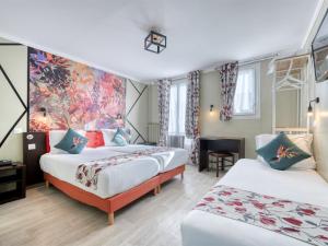 Una habitación de hotel con dos camas y un cuadro en la pared. en Hotel de Belfort, en París