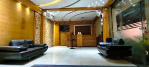 a lobby with black leather chairs and a waiting room at The Lotus Boutique Hotel in Chikmagalūr