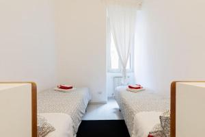 duas camas em um quarto com janela em Suite Boschetto Holidays em Roma