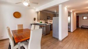 una sala da pranzo e una cucina con tavolo e sedie di Elegant Condo with Brand-New Fixtures, Shaded Tropical Terrace, and Secluded Beach Access a Playa Flamingo