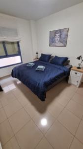 a bedroom with a bed with a blue comforter at Ap Skerup Calpe City cerca Playa in Calpe