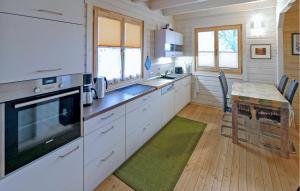 a kitchen with white cabinets and a wooden floor at Ferienhaus Tollenseheim in Krickow