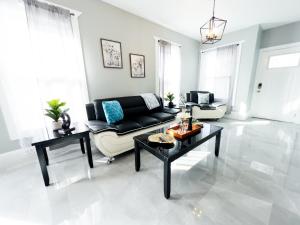 Una sala de estar con un sofá negro y una mesa. en Comfy 4BR-Free Parking-Wi-Fi in Niagara Falls NY, en Niagara Falls 13 fotos más