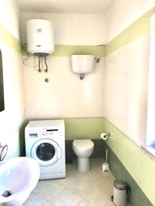 Un baño con lavadora y un inodoro. en Pizzo Beach Studio 121G, en Pizzo