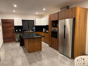 a kitchen with wooden cabinets and a stainless steel refrigerator at Residencial Sabina in Cabo San Lucas