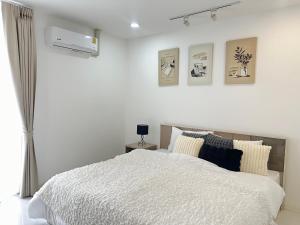 una camera da letto con un letto bianco con quattro immagini sul muro di SR Complex a Chiang Mai Altre 21 foto