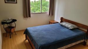 a bedroom with a blue bed and a window at Quarto e banheiro privativos no Jardins in São Paulo