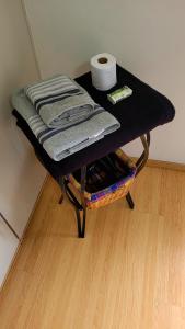 a black table with towels and a basket of toilet paper at Quarto e banheiro privativos no Jardins in São Paulo +11 photos