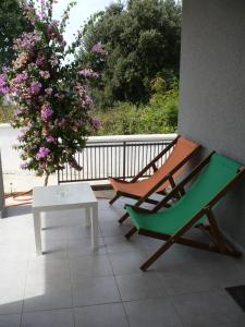 um pátio com um banco, uma mesa e uma árvore em Apartments Pure Magic em Utjeha