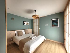 Ένα ή περισσότερα κρεβάτια σε δωμάτιο στο Logement avec jacuzzi et sauna en terrasse, belle vue panoramique