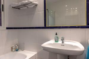 a white bathroom with a sink and a mirror at Plaza Unamuno - Casco Viejo - PARKING opcional in Bilbao +22 photos