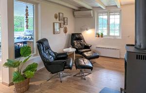 two leather chairs and a table in a living room at Beautiful Home In Blåvand With Sauna in Blåvand