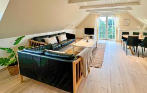 a living room with a couch and a table at Beautiful Home In Blåvand With Sauna in Blåvand