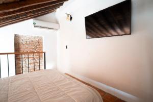 a bedroom with a bed and a flat screen tv at El monarca in Mompos
