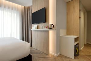 エヴォラにあるHoliday Inn Express Évora by IHGのベッドと薄型テレビがあるホテルの部屋