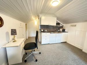 a kitchen with a desk and a chair in a room at Stor hybel in Tromsø