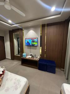 a room with a bed and a tv on a wall at HOTEL PREMIER CHOICE - JUST 50 Meters FROM AJMER SHARIF DARGAH in Ajmer