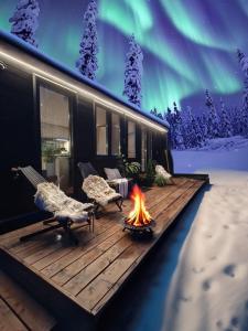 アカスロンポロにあるLapland Riverside Cabin 4 HILLA , Ylläs, Tiny Home with Sauna, Fireplace, Terrace, BBQ, Wifi, Ski, Fishing, Pets OKの暖炉(椅子付)