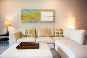 a living room with a white couch and a table at Chic Minimalist Condo with Swimming Pool, Hot Tub, and Beach Club Access in Coco
