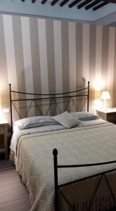 ein Schlafzimmer mit einem großen Bett mit gestreifter Wand in der Unterkunft Antico Portale Ospitalità Diffusa in Acquasparta