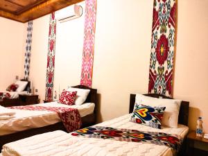 a room with two beds and a window at "Sofia" Guest House-Hostel in Samarkand