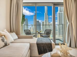 a living room with a couch and a large window at SmartStay at Burj Royale - Full Burj Khalifa View - Brand New Luxury Apartments in Dubai