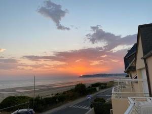 a view of the beach at sunset from a condo at Les balcons des Ecréhous - Duplex front de mer in Saint-Jean-de-la-Rivière