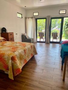 een slaapkamer met een bed en een houten vloer bij Peaceful Hideaway in Santa Cruz La Laguna