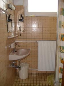 a small bathroom with a sink and a bucket at Pension Kroth an der Mosel in Briedel