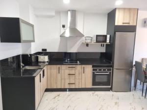 a kitchen with black counters and stainless steel appliances at Aguete III in Marín +10 photos
