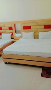 two beds sitting next to each other in a room at Malinum Grande Guest House in Lahore +6 photos
