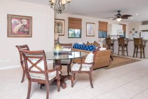 Un comedor y una sala de estar con mesa y sillas. en Dazzling End Unit in Coco with Lots of Windows and Light Sleeps 8, en Coco