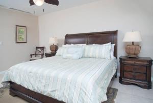 a bedroom with a large bed with blue pillows at Spacious Beach-Inspired Condo with Resort-Style Amenities & Beach Club Access in Coco +24 photos