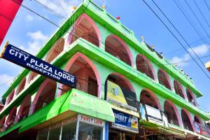 a green building with a sign in front of it at City Plaza Lodge in Karaikal