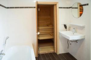 a bathroom with a sink and a mirror and a shower at Weidevilla 14 auf Ameland in Hollum +30 photos
