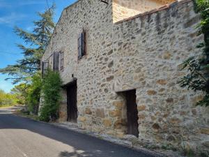 een oud stenen gebouw met twee deuren in een straat bij La Roche 10 in Aigues-Vives