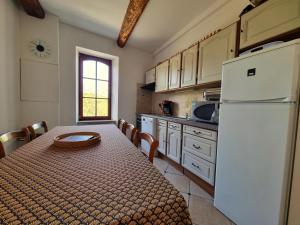 een keuken met een tafel en een witte koelkast bij La Roche 10 in Aigues-Vives
