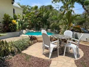 a patio with a table and chairs next to a pool at Casa Kahakai 1 in Chacala