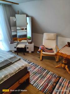 a bedroom with a bed and a chair and a mirror at Domek Kutowa in Kutowa