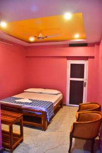 a bedroom with a bed and a chair in it at City Plaza Lodge in Karaikal +2 photos